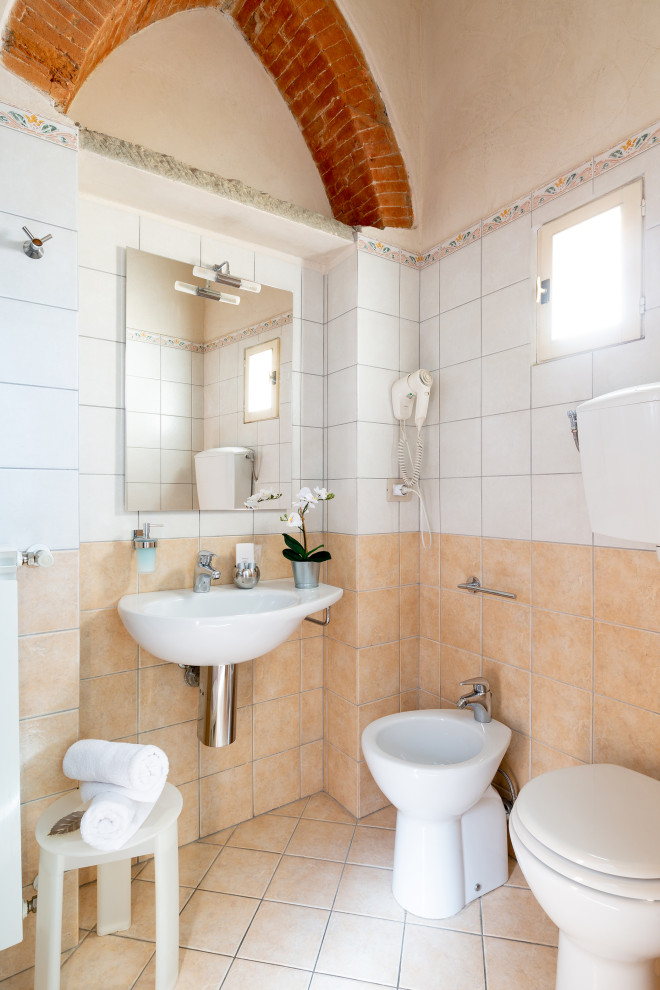 Diseño de cuarto de baño mediterráneo de tamaño medio con sanitario de una pieza, baldosas y/o azulejos beige, baldosas y/o azulejos blancos, baldosas y/o azulejos de porcelana, suelo de baldosas de porcelana, aseo y ducha, lavabo suspendido y suelo beige