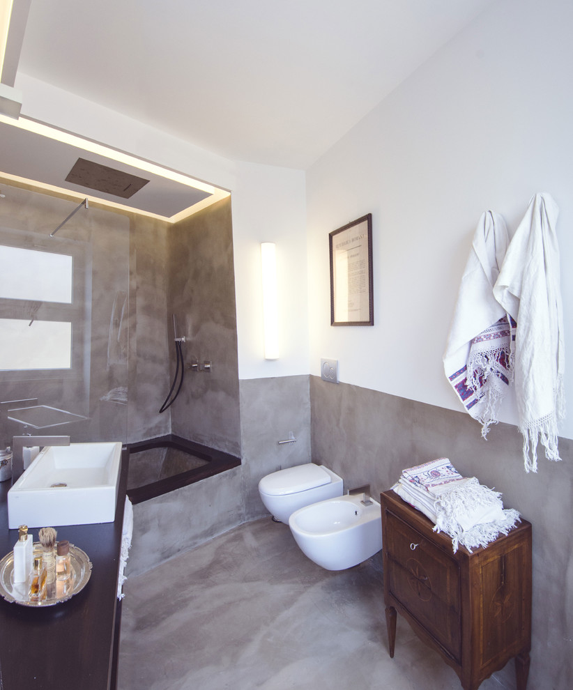 Свежая идея для дизайна: большая серо-белая ванная комната в средиземноморском стиле с ванной в нише, душем над ванной, инсталляцией, белыми стенами, бетонным полом, душевой кабиной и раковиной с несколькими смесителями - отличное фото интерьера