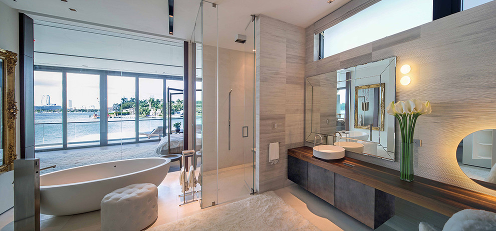 Exemple d'une salle de bain principale bord de mer avec une baignoire indépendante, une douche à l'italienne, une vasque et un plan de toilette en bois.