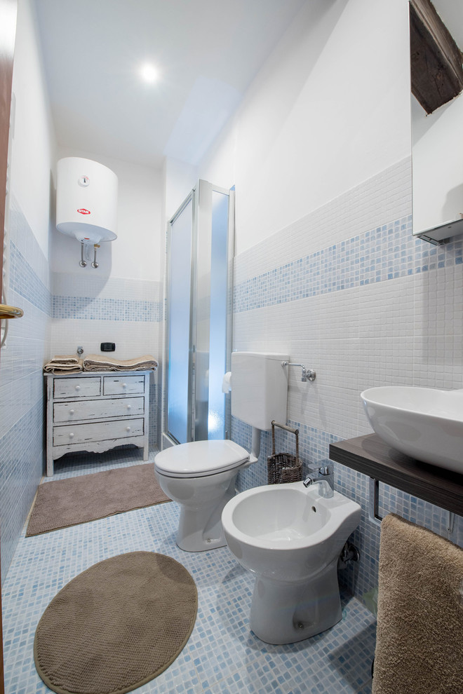 Idee per una piccola stanza da bagno costiera con ante di vetro, ante beige, WC a due pezzi, piastrelle blu, piastrelle a mosaico, pareti bianche, pavimento con piastrelle a mosaico, lavabo a bacinella, top in legno e pavimento blu