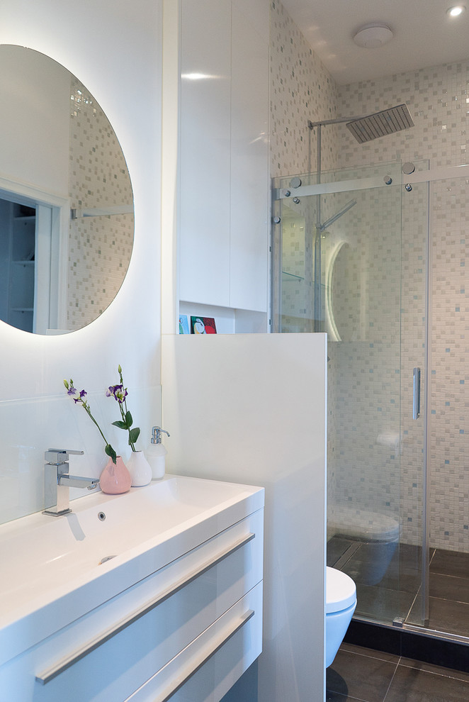 Immagine di una stanza da bagno minimal di medie dimensioni con ante lisce, ante bianche, WC sospeso, piastrelle beige, piastrelle a mosaico, pareti bianche, lavabo integrato e porta doccia scorrevole