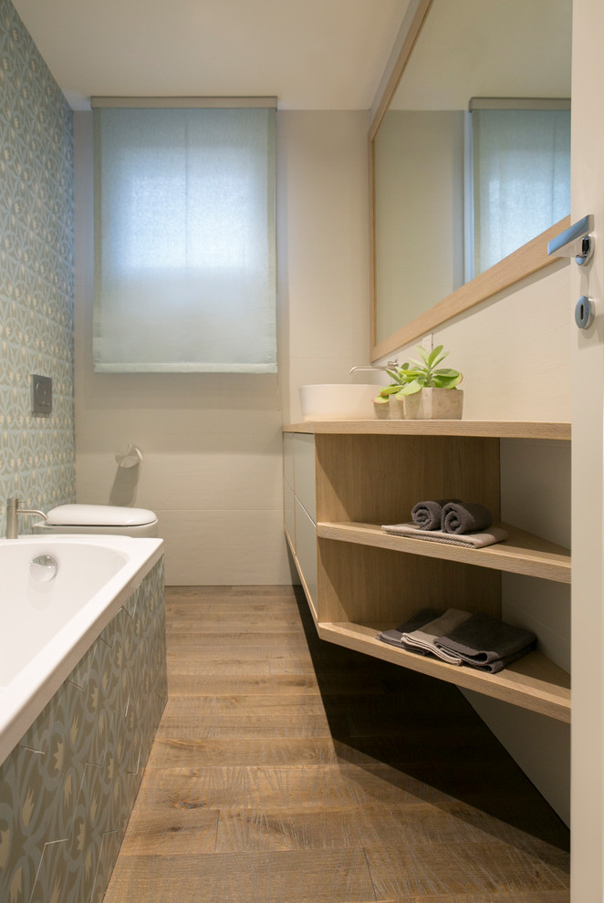Cette photo montre une salle de bain principale moderne en bois clair de taille moyenne avec un placard à porte plane, une baignoire posée, WC séparés, des carreaux de béton, parquet foncé, une vasque et un plan de toilette en bois.