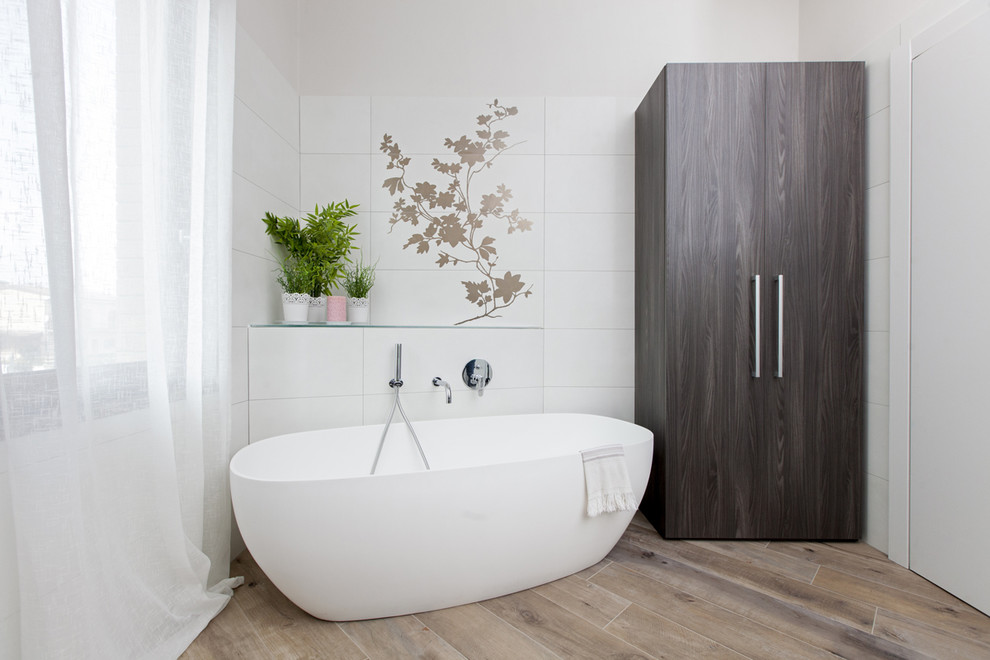 Immagine di una grande stanza da bagno padronale minimal con doccia alcova, vasca freestanding, piastrelle bianche, pareti bianche e parquet chiaro