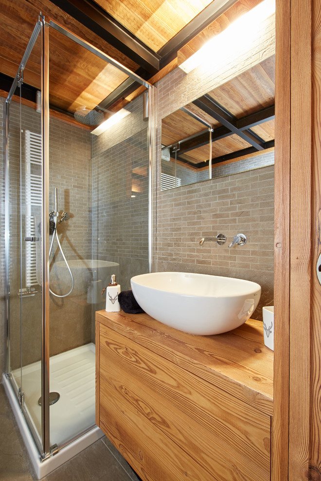 Modernes Duschbad mit Eckdusche, Wandtoilette, grauen Fliesen, grauer Wandfarbe, flächenbündigen Schrankfronten, hellbraunen Holzschränken, Aufsatzwaschbecken, Waschtisch aus Holz, Keramikfliesen und Keramikboden in Turin