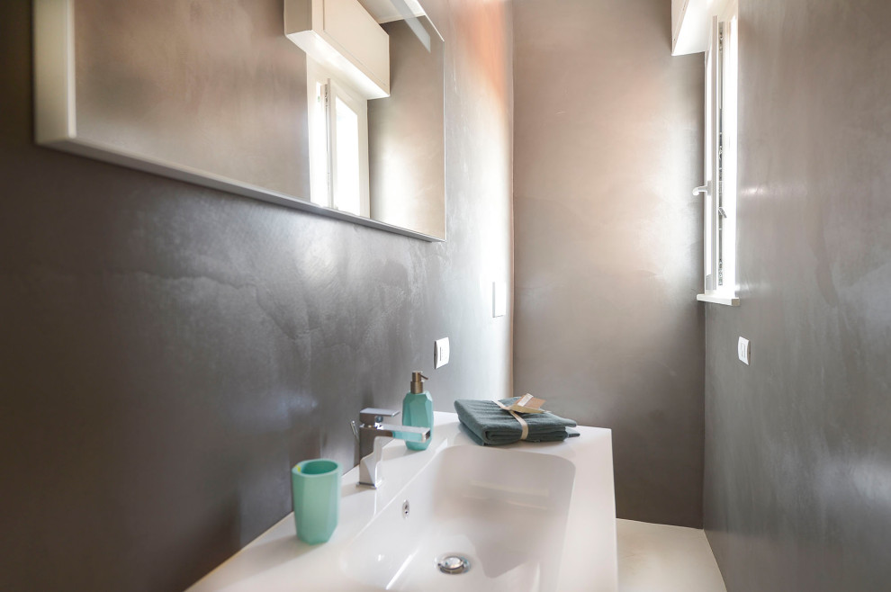 Foto di una piccola stanza da bagno minimalista con ante grigie, pareti grigie, lavabo integrato, top bianco, un lavabo e mobile bagno sospeso
