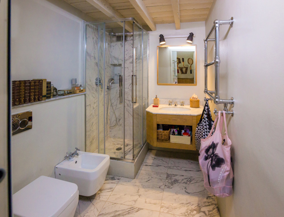 Inredning av ett shabby chic-inspirerat vit vitt badrum med dusch, med öppna hyllor, skåp i ljust trä, en hörndusch, en toalettstol med separat cisternkåpa, vita väggar, marmorgolv, ett undermonterad handfat, marmorbänkskiva och dusch med skjutdörr