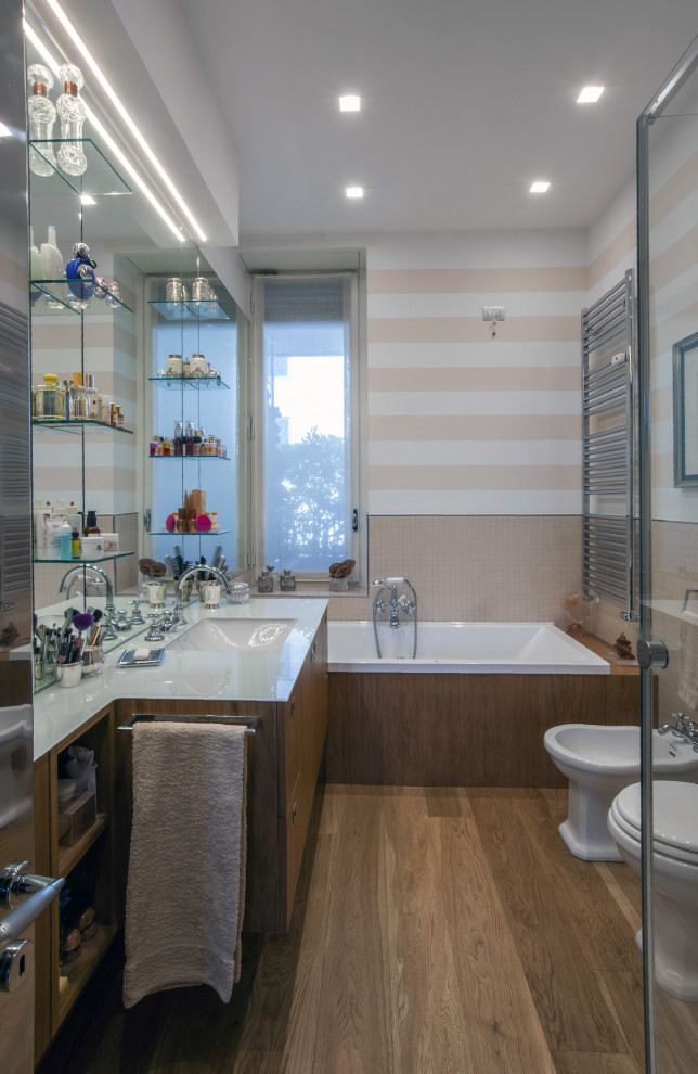 Réalisation d'une salle de bain principale design en bois brun de taille moyenne avec un placard à porte plane, une baignoire posée, un carrelage beige, un mur multicolore, un lavabo encastré, un sol marron, un plan de toilette gris, meuble simple vasque et meuble-lavabo encastré.