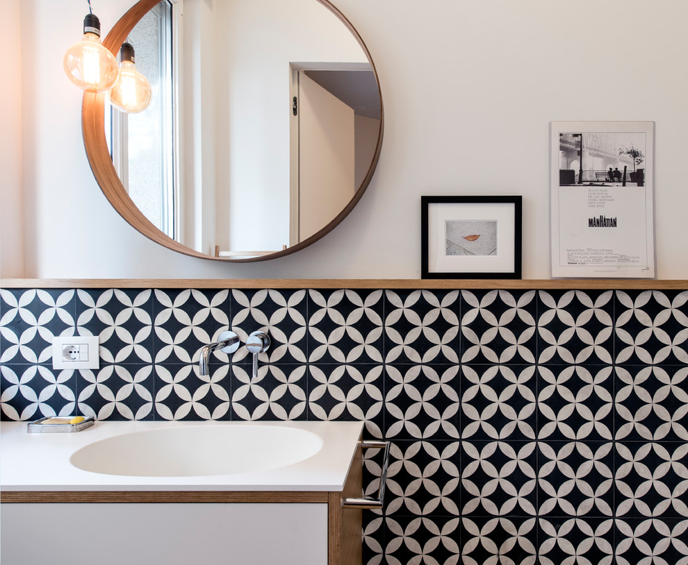 На фото: главная ванная комната среднего размера в скандинавском стиле с плоскими фасадами, светлыми деревянными фасадами, душем в нише, раздельным унитазом, черно-белой плиткой, терракотовой плиткой, белыми стенами, бетонным полом, монолитной раковиной, столешницей из искусственного камня, серым полом, душем с распашными дверями и белой столешницей