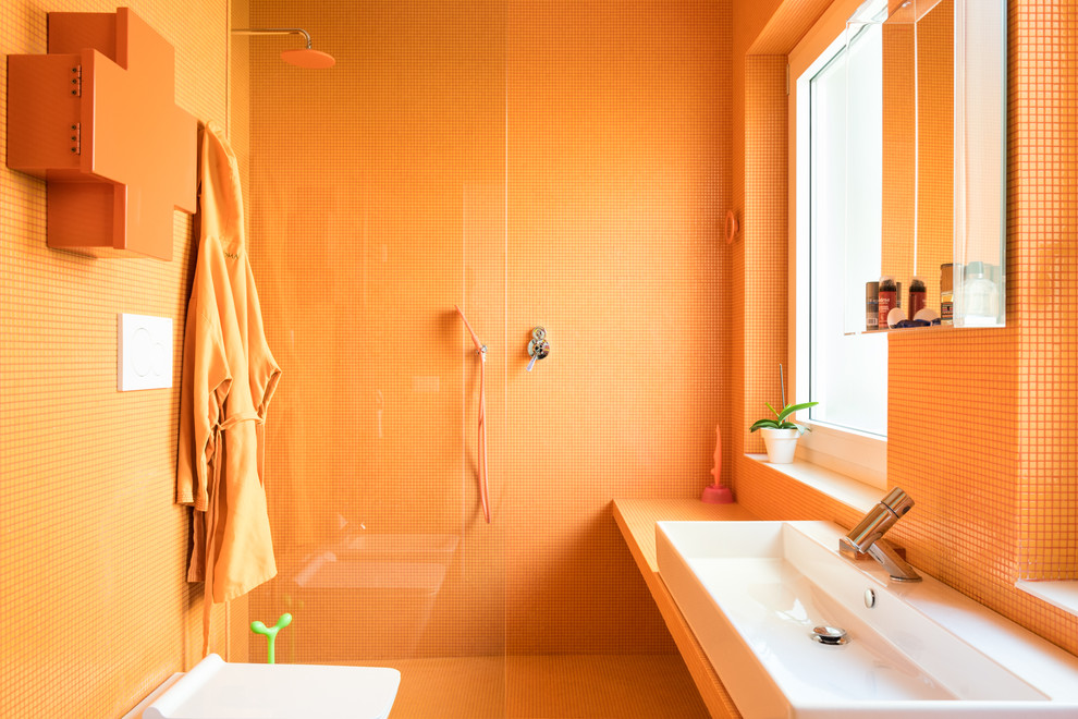 На фото: ванная комната в стиле фьюжн с оранжевыми фасадами, открытым душем, раздельным унитазом, оранжевой плиткой, плиткой мозаикой, оранжевыми стенами, светлым паркетным полом, душевой кабиной, настольной раковиной, столешницей из плитки, открытым душем и оранжевой столешницей