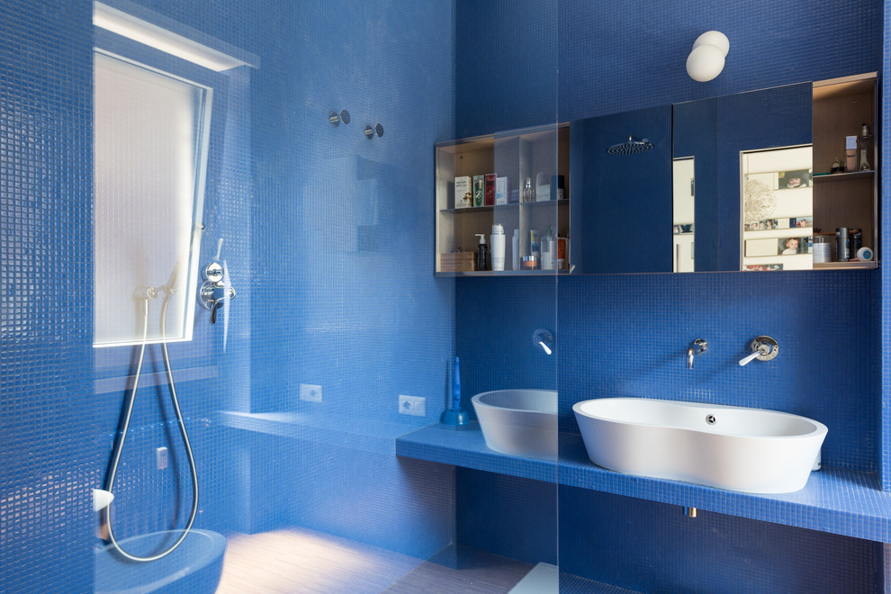 Inspiration för eklektiska blått badrum med dusch, med blå skåp, en öppen dusch, en toalettstol med separat cisternkåpa, blå kakel, mosaik, blå väggar, ljust trägolv, ett fristående handfat, kaklad bänkskiva och med dusch som är öppen