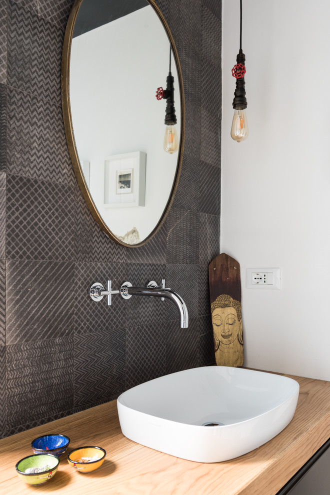 Exempel på ett modernt brun brunt en-suite badrum, med släta luckor, svarta skåp, en toalettstol med separat cisternkåpa, porslinskakel, vita väggar, ljust trägolv, ett fristående handfat och träbänkskiva