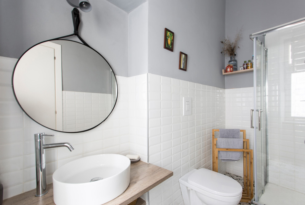 Источник вдохновения для домашнего уюта: ванная комната среднего размера в скандинавском стиле с открытыми фасадами, коричневыми фасадами, угловым душем, раздельным унитазом, белой плиткой, керамической плиткой, разноцветными стенами, полом из мозаичной плитки, душевой кабиной, настольной раковиной, столешницей из дерева, разноцветным полом, душем с раздвижными дверями и коричневой столешницей