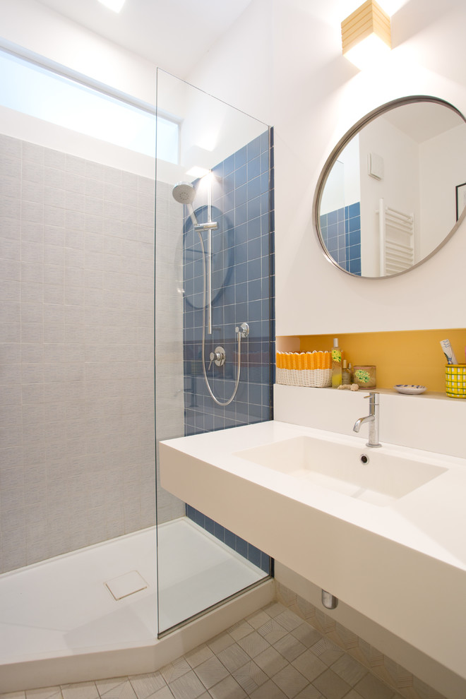 Stilmix Duschbad mit Wandtoilette mit Spülkasten, weißer Wandfarbe, Terrakottaboden, Trogwaschbecken, buntem Boden und weißer Waschtischplatte in Neapel