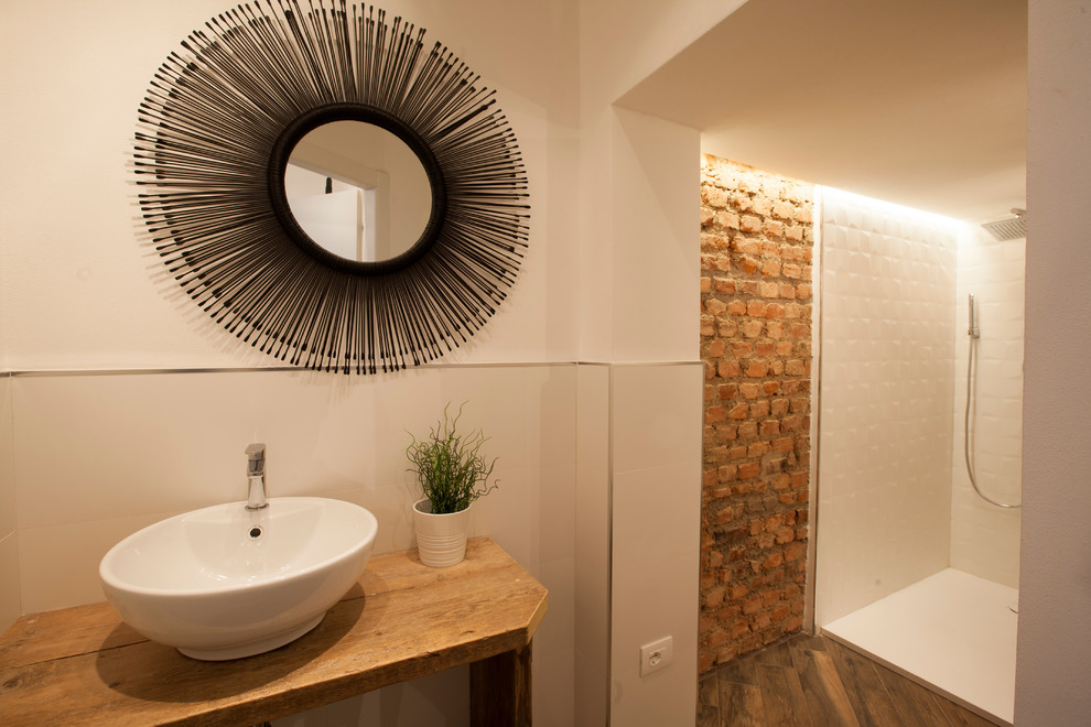 This is an example of a medium sized industrial shower room bathroom in Milan with light wood cabinets, a two-piece toilet, white tiles, ceramic tiles, ceramic flooring, a vessel sink, wooden worktops and brown floors.