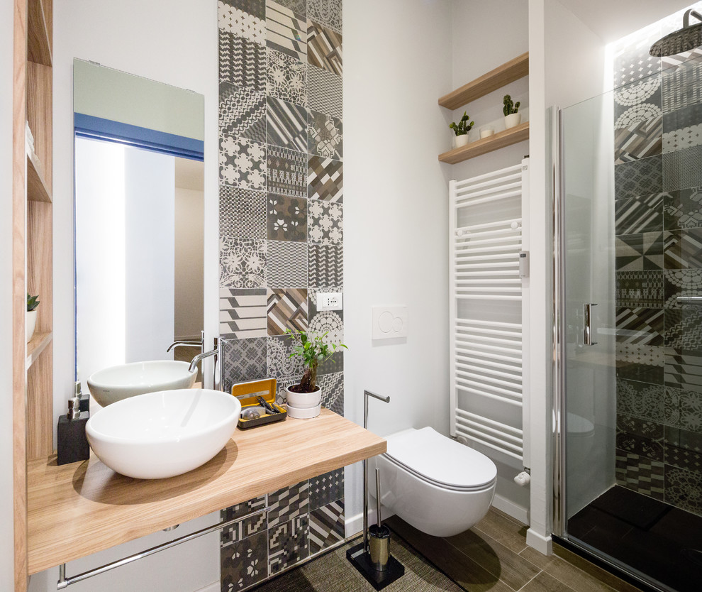 Inspiration för små moderna brunt badrum med dusch, med öppna hyllor, skåp i ljust trä, träbänkskiva, en vägghängd toalettstol, grå kakel, vita väggar, ett fristående handfat, grått golv och dusch med gångjärnsdörr