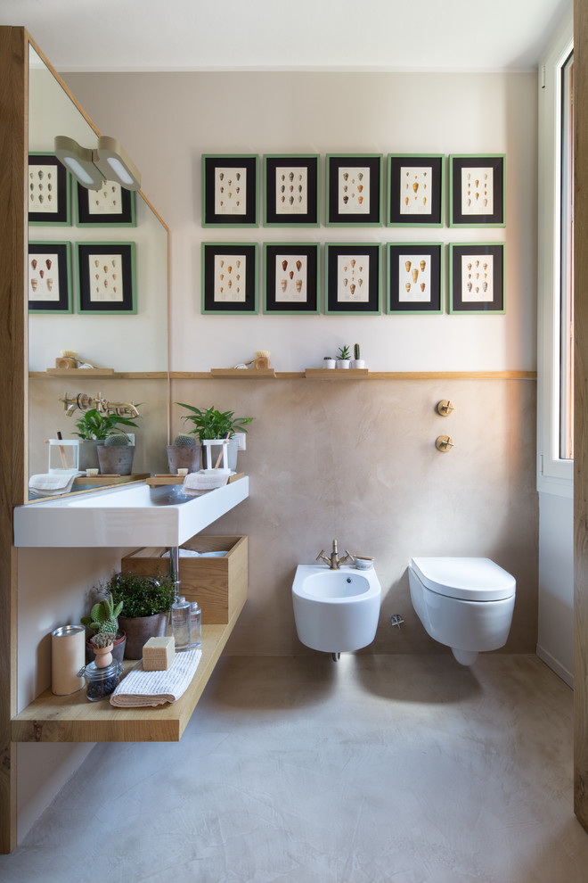 Maritimes Badezimmer mit offenen Schränken, hellen Holzschränken, Wandtoilette, Waschtischkonsole und grauem Boden in Mailand