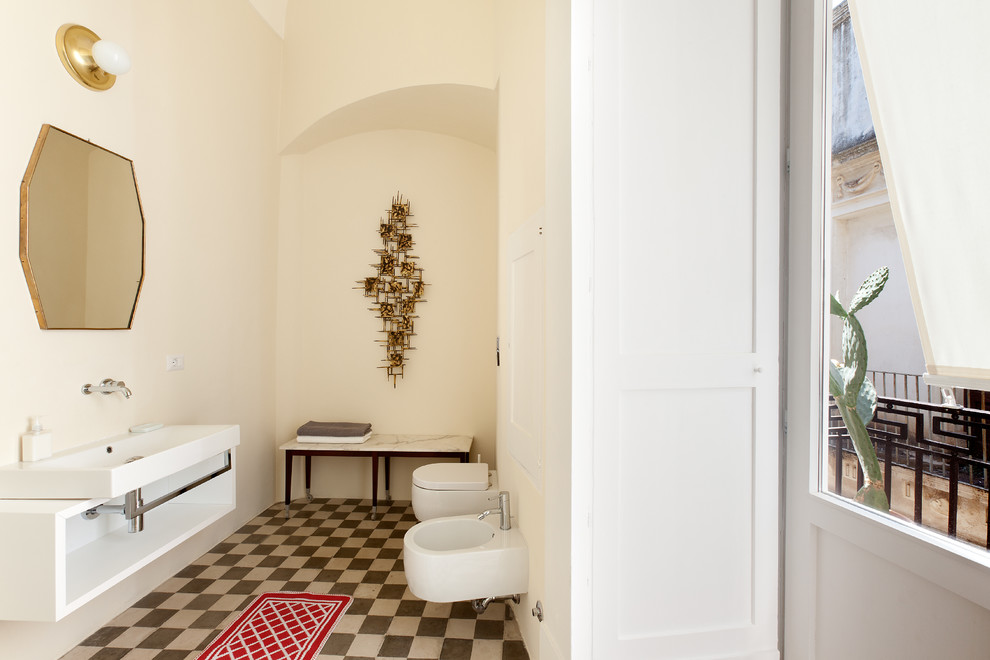 Diseño de cuarto de baño mediterráneo de tamaño medio con puertas de armario blancas, sanitario de pared, paredes blancas, suelo de baldosas de terracota y lavabo de seno grande