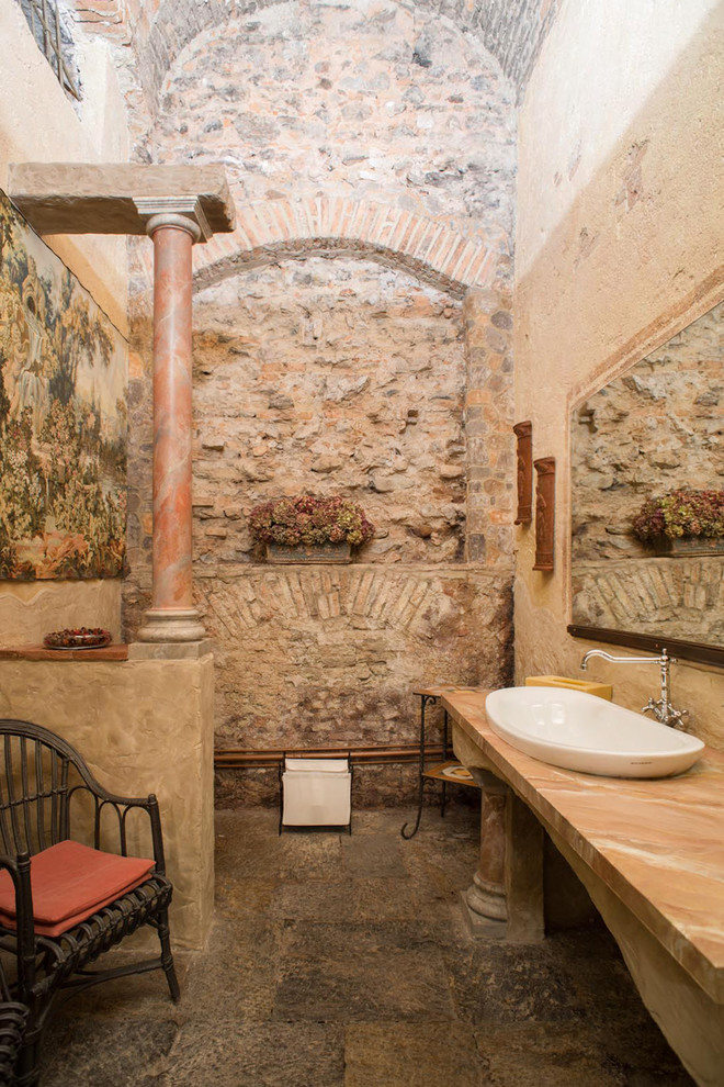 他の地域にある地中海スタイルのおしゃれな浴室 (大理石の洗面台、石タイル、ベッセル式洗面器、マルチカラーの床、マルチカラーの洗面カウンター) の写真