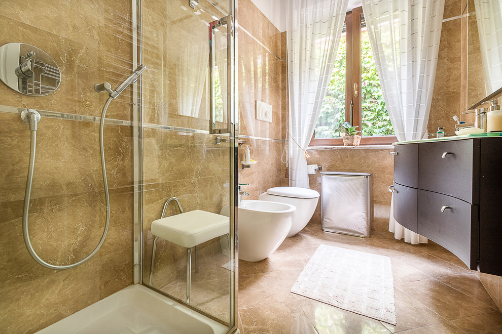 Immagine di una stanza da bagno con doccia chic di medie dimensioni con ante lisce, ante marroni, doccia ad angolo, lastra di pietra, pavimento in marmo, top in vetro e porta doccia a battente
