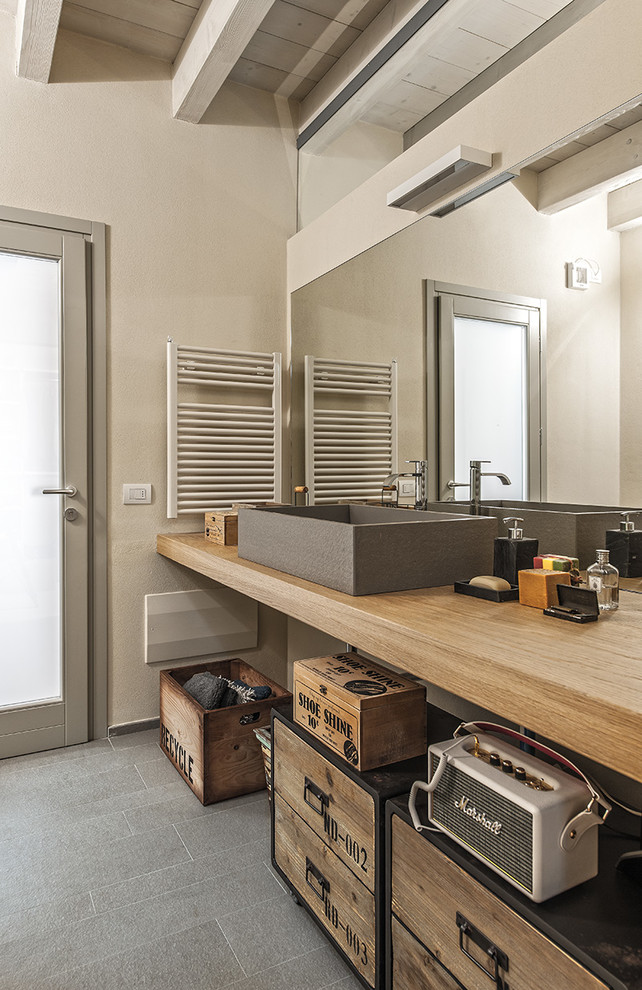 Пример оригинального дизайна: ванная комната в средиземноморском стиле с серыми стенами, настольной раковиной, столешницей из дерева, серым полом и бежевой столешницей