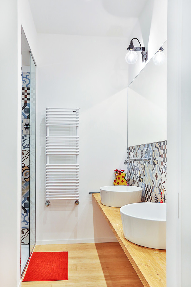 Photo of a contemporary bathroom in Turin with multi-coloured tiles, ceramic tiles, a vessel sink and wooden worktops.