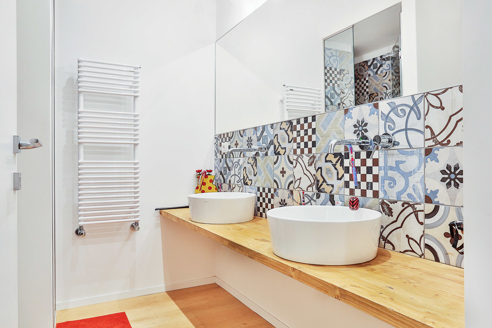 На фото: ванная комната в современном стиле с настольной раковиной, столешницей из дерева, разноцветной плиткой и керамической плиткой