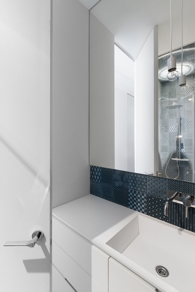 Cette photo montre une petite douche en alcôve tendance avec WC séparés, un carrelage bleu, un mur blanc et un sol en bois brun.