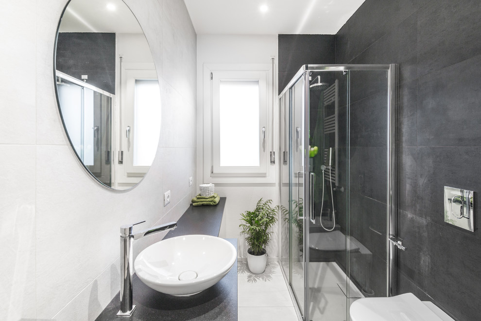 Idéer för att renovera ett litet funkis badrum med dusch, med vita skåp, en vägghängd toalettstol, grå kakel, svart och vit kakel, keramikplattor, vita väggar, ett fristående handfat, en hörndusch, klinkergolv i keramik, granitbänkskiva, vitt golv och dusch med skjutdörr