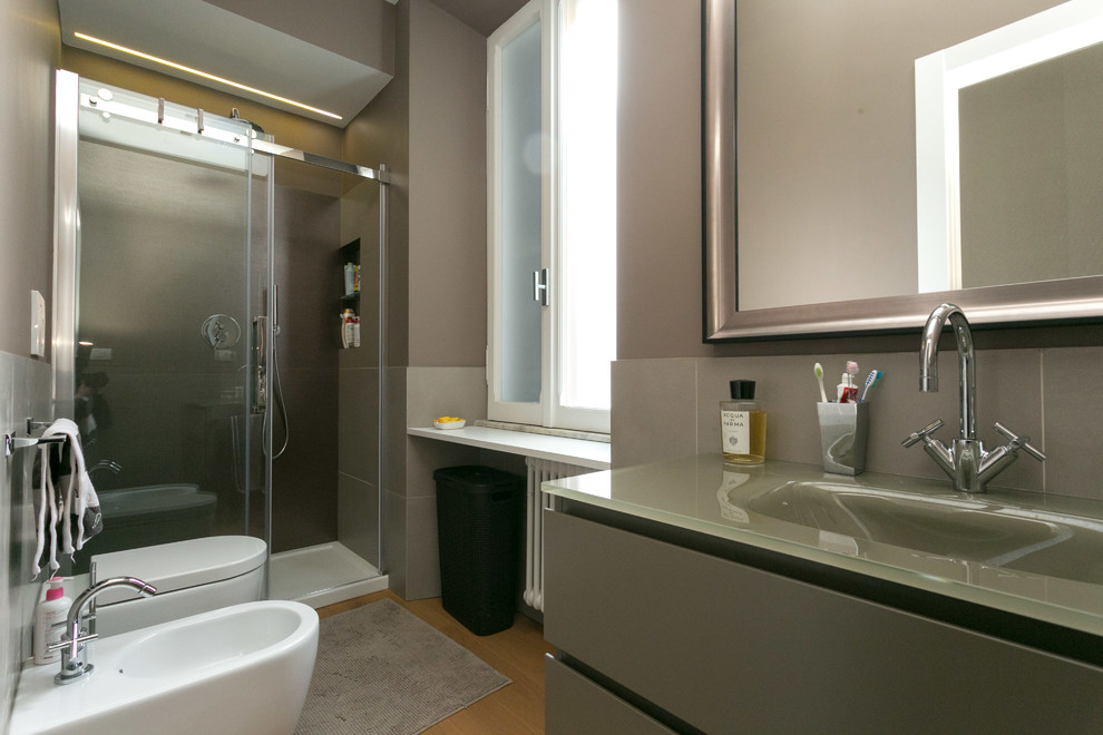 Esempio di una stanza da bagno con doccia contemporanea con parquet chiaro e top in vetro
