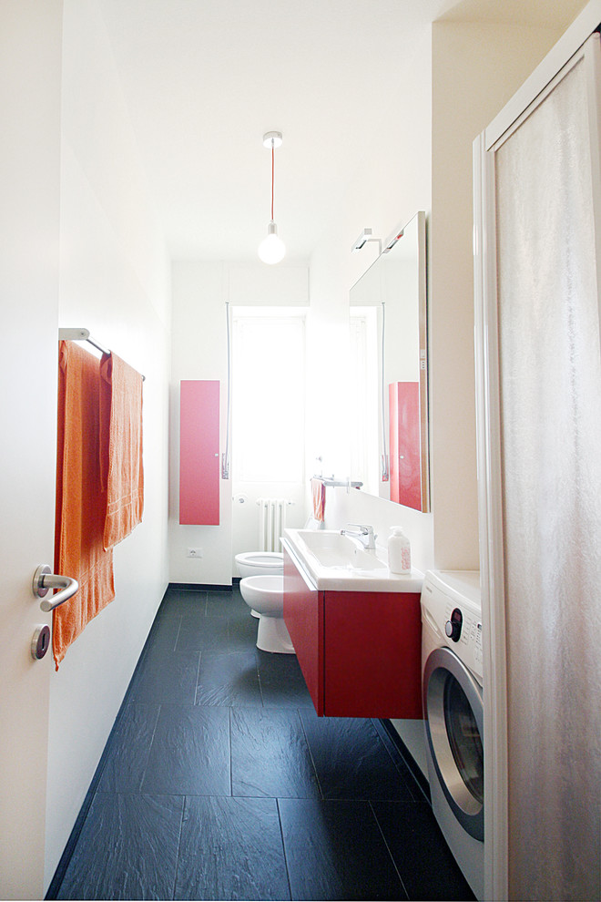На фото: маленькая ванная комната в современном стиле с плоскими фасадами, красными фасадами, душем в нише, раздельным унитазом, белой плиткой, белыми стенами, полом из сланца, душевой кабиной, подвесной раковиной, столешницей из искусственного камня, черным полом, душем с раздвижными дверями и белой столешницей для на участке и в саду с