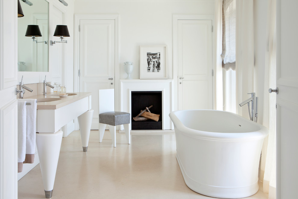 Modelo de cuarto de baño principal actual con bañera exenta, paredes blancas, suelo de baldosas de porcelana y lavabo tipo consola
