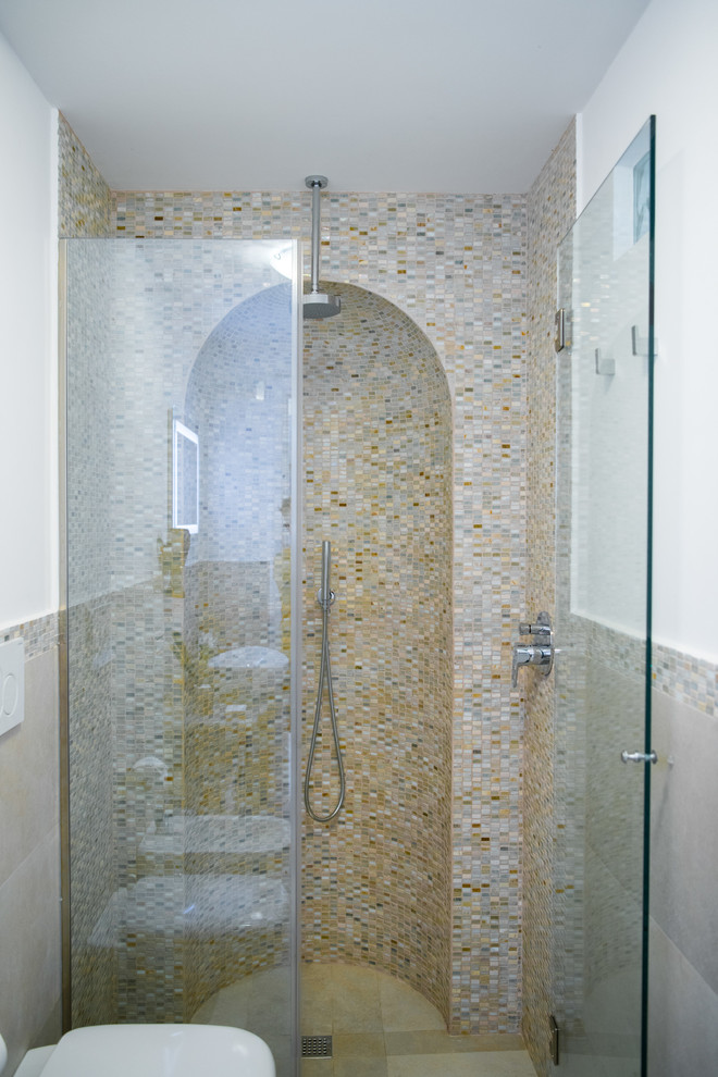 На фото: маленькая ванная комната в средиземноморском стиле с душем без бортиков, бежевой плиткой, плиткой мозаикой, душевой кабиной, душем с распашными дверями и нишей для на участке и в саду с