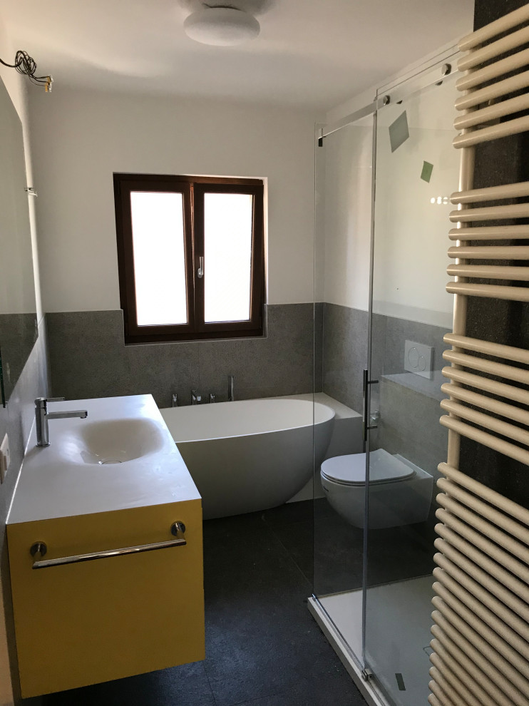 Bathroom - mid-sized modern master gray tile and porcelain tile porcelain tile and single-sink bathroom idea in Other with beaded inset cabinets, yellow cabinets, a wall-mount toilet, white walls, an integrated sink, solid surface countertops, white countertops, a niche and a floating vanity