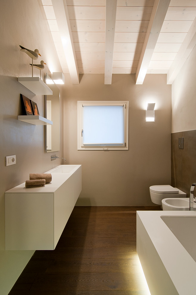 Идея дизайна: главная ванная комната в современном стиле с плоскими фасадами, белыми фасадами, инсталляцией, бежевыми стенами, темным паркетным полом и монолитной раковиной