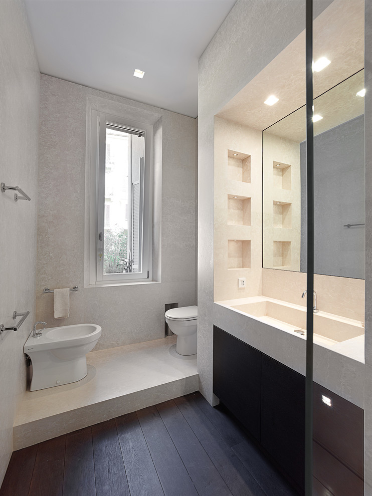 Idée de décoration pour une salle de bain minimaliste avec un placard à porte plane, WC à poser, un mur gris, parquet foncé et un lavabo intégré.