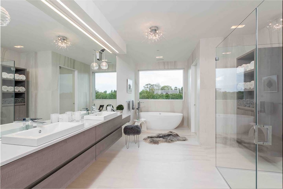 Свежая идея для дизайна: главная ванная комната в современном стиле с коричневой плиткой, керамогранитной плиткой, бежевыми стенами, полом из керамогранита, бежевым полом, плоскими фасадами, серыми фасадами, отдельно стоящей ванной, настольной раковиной, душем с распашными дверями и серой столешницей - отличное фото интерьера