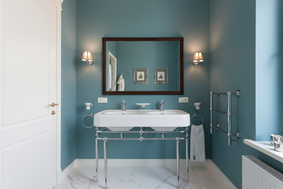 Foto de cuarto de baño clásico con paredes azules, lavabo tipo consola, suelo blanco y espejo con luz