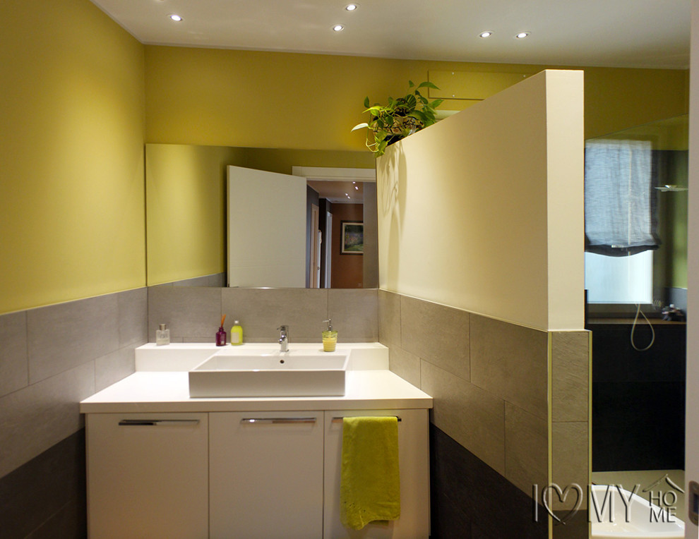 Immagine di una stanza da bagno con doccia minimalista di medie dimensioni con ante bianche, doccia a filo pavimento, piastrelle grigie, pareti verdi e lavabo a bacinella