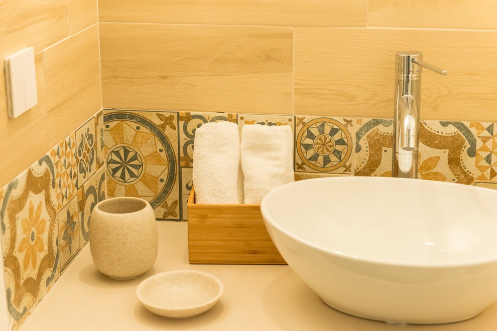 Пример оригинального дизайна: маленькая ванная комната в средиземноморском стиле с открытыми фасадами, белыми фасадами, угловой ванной, душем без бортиков, раздельным унитазом, бежевой плиткой, керамогранитной плиткой, белыми стенами, полом из керамогранита, душевой кабиной, настольной раковиной, столешницей из дерева, бежевым полом, душем с распашными дверями и белой столешницей для на участке и в саду