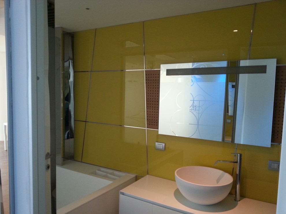 Cette image montre une salle de bain design de taille moyenne avec un bain bouillonnant, un combiné douche/baignoire, WC suspendus, un mur jaune et un sol en bois brun.