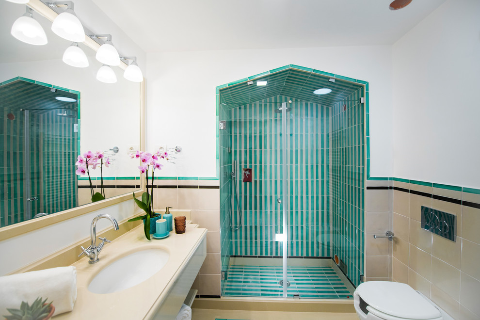 他の地域にある地中海スタイルのおしゃれな浴室 (アルコーブ型シャワー、マルチカラーのタイル、白い壁、アンダーカウンター洗面器、開き戸のシャワー、ベージュのカウンター) の写真