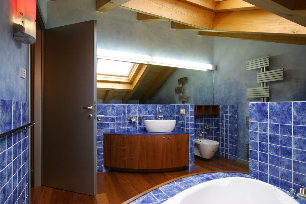 Inspiration pour une salle de bain principale design en bois foncé de taille moyenne avec un placard en trompe-l'oeil, une baignoire d'angle, des carreaux de céramique, un mur bleu, un sol en bois brun, une vasque, un plan de toilette en surface solide et un sol marron.