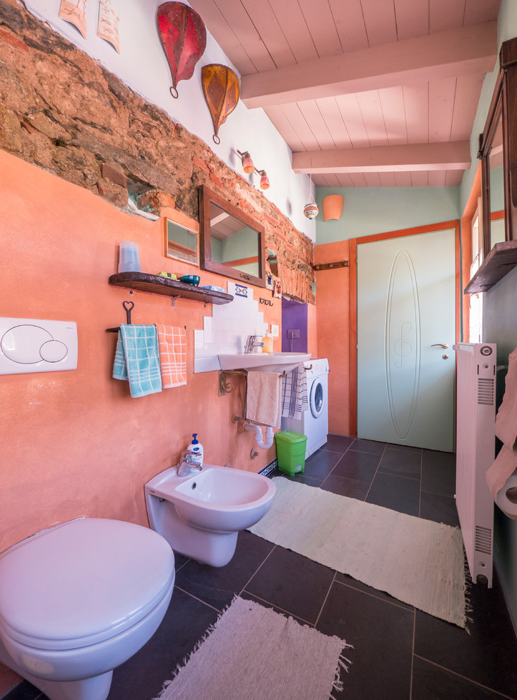Ejemplo de cuarto de baño ecléctico con lavabo suspendido y parades naranjas