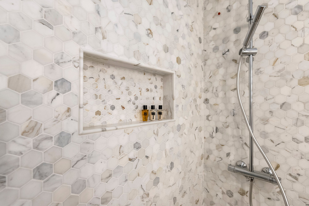 Kleines Modernes Duschbad mit schwarzen Schränken, freistehender Badewanne, Nasszelle, Wandtoilette mit Spülkasten, hellem Holzboden, Aufsatzwaschbecken und Falttür-Duschabtrennung in Mailand