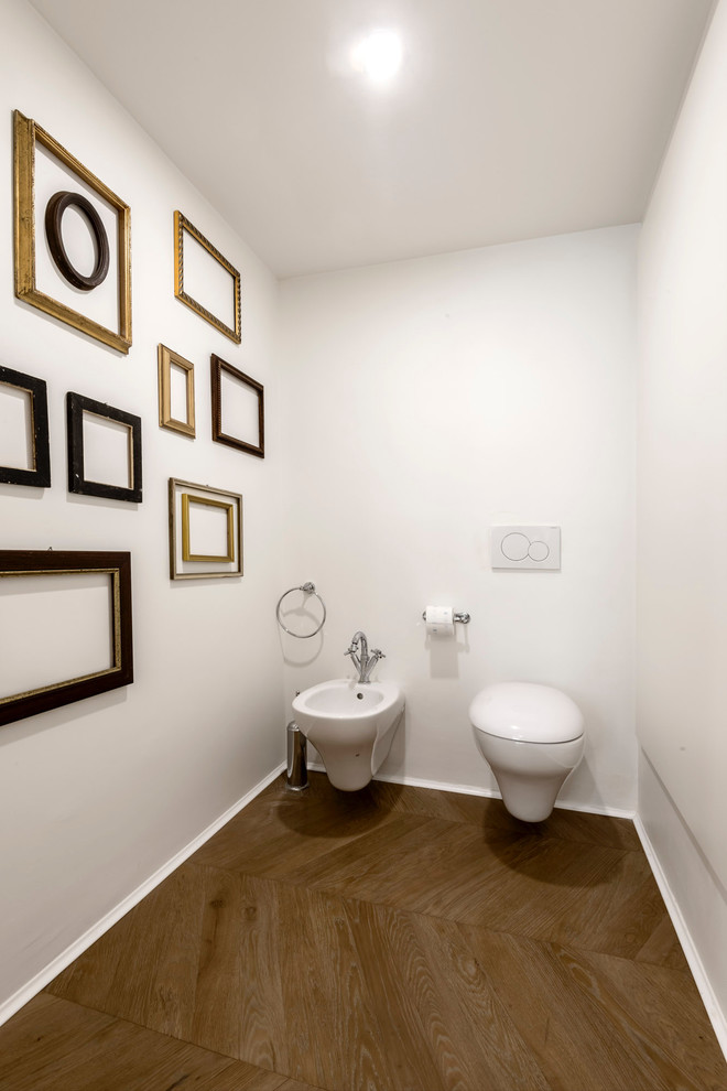 Пример оригинального дизайна: большой туалет в современном стиле с раздельным унитазом, светлым паркетным полом и настольной раковиной