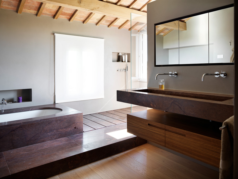 Idéer för ett stort modernt badrum med dusch, med släta luckor, skåp i mellenmörkt trä, en kantlös dusch, grå väggar, mellanmörkt trägolv, ett integrerad handfat och ett undermonterat badkar