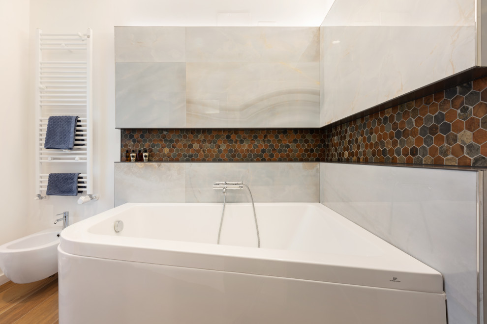 Photo of a large contemporary ensuite bathroom in Rome with open cabinets, brown cabinets, a corner bath, a wall mounted toilet, brown tiles, porcelain tiles, white walls, porcelain flooring, a vessel sink, wooden worktops, brown floors and brown worktops.