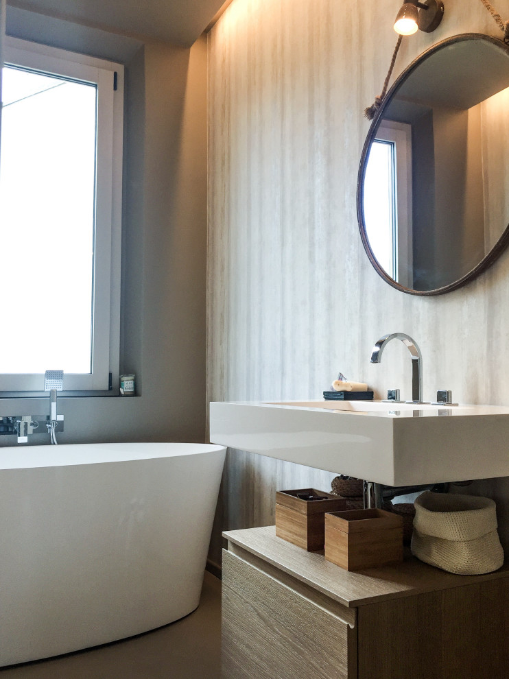 Exempel på ett mellanstort modernt vit vitt en-suite badrum, med beige skåp, ett fristående badkar, grå kakel, grå väggar, ett integrerad handfat, grått golv och släta luckor