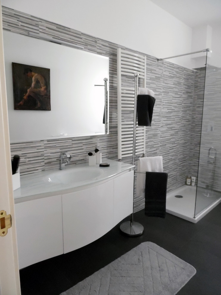 Idéer för mellanstora funkis badrum med dusch, med släta luckor, vita skåp, en öppen dusch, en toalettstol med separat cisternkåpa, svart och vit kakel, stickkakel, vita väggar, skiffergolv, ett konsol handfat och bänkskiva i glas