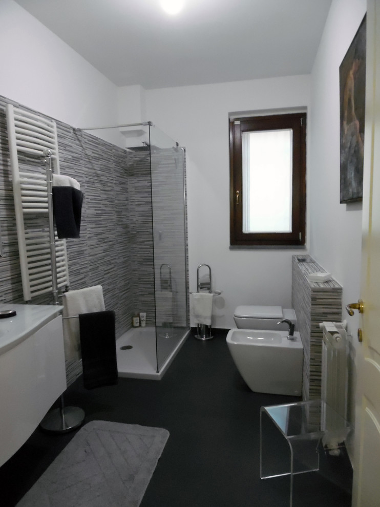 Exemple d'une salle d'eau moderne de taille moyenne avec un placard à porte plane, des portes de placard blanches, une douche ouverte, WC séparés, un carrelage noir et blanc, des carreaux en allumettes, un mur blanc, un sol en ardoise, un plan vasque et un plan de toilette en verre.